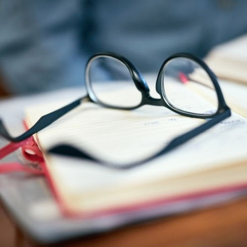 reading glasses on top of a notebook.
